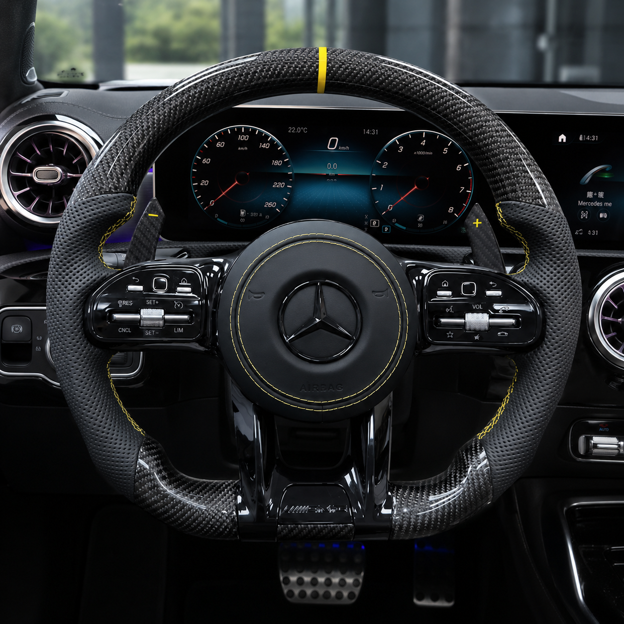 Gloss carbon fiber Mercedes-Benz steering wheel installed in luxury cockpit with perforated leather grips and yellow center stripe.