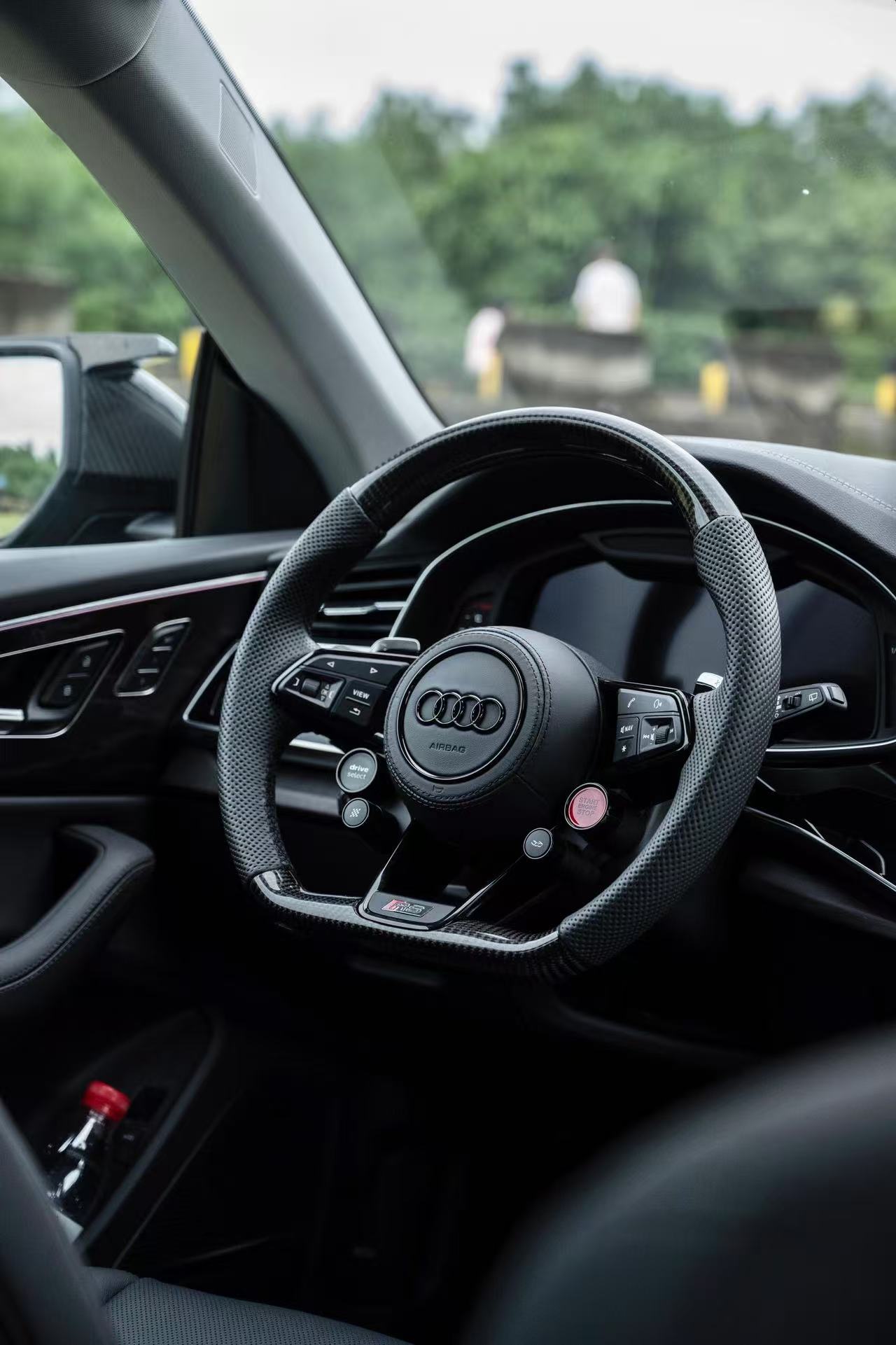Custom flat-bottom Audi steering wheel wrapped in premium black perforated Nappa leather with subtle black stitching installed in car