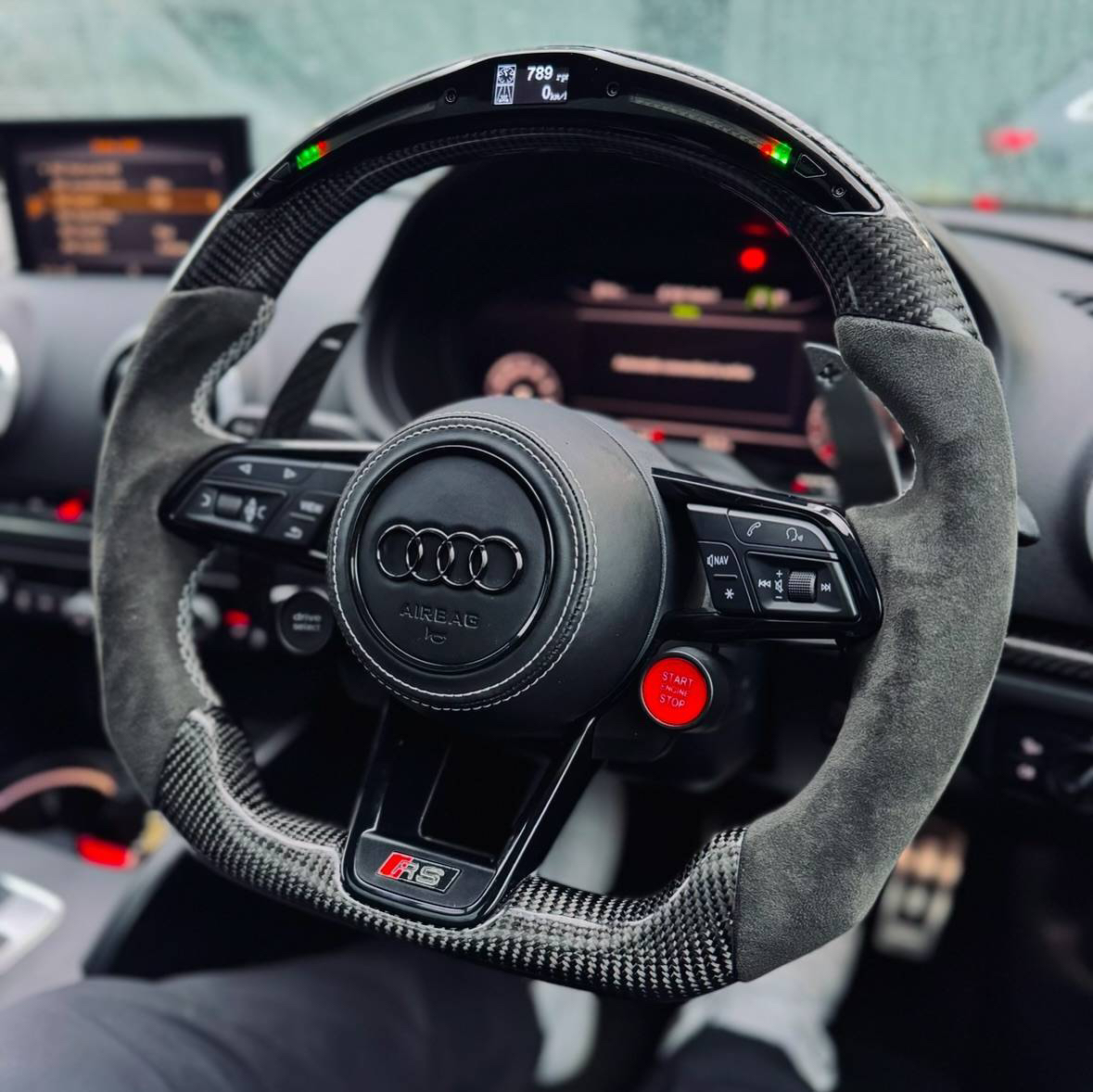 Audi carbon fiber steering wheel with integrated smart LED shift light display, Alcantara sides, and red stitching installed in cabin
